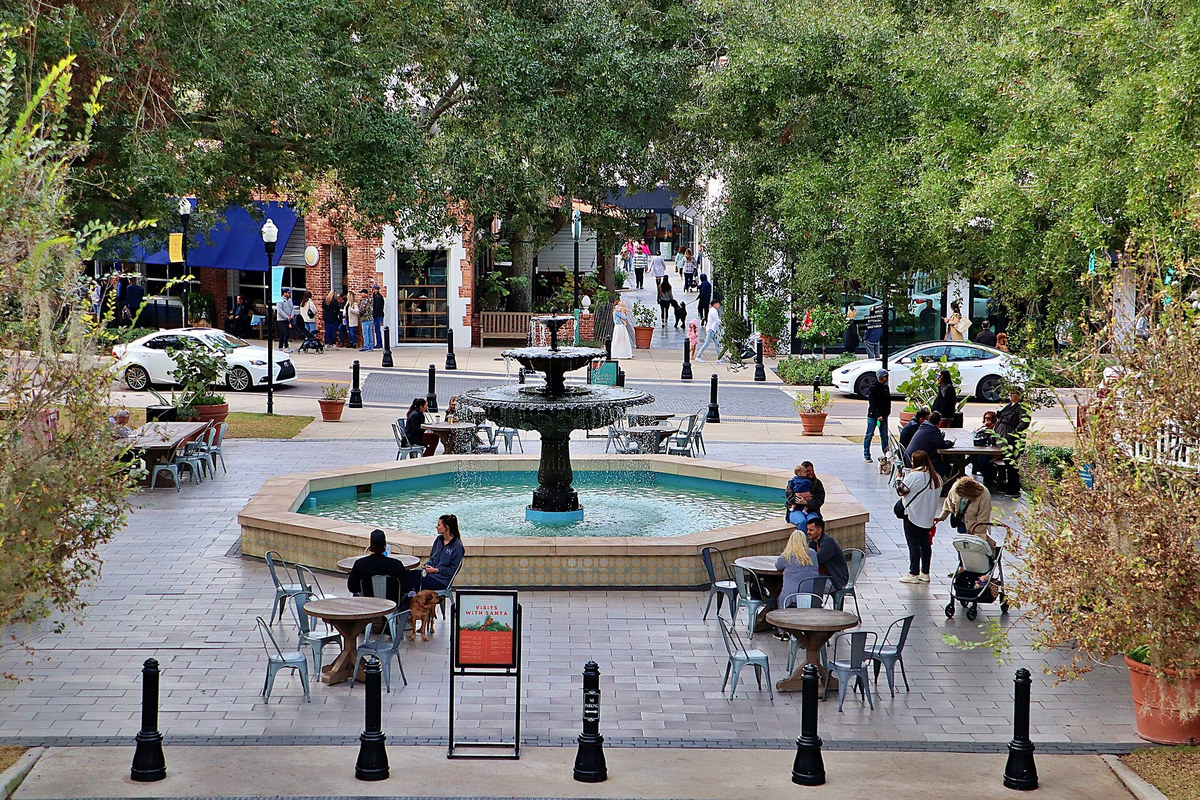 People sitting around the fountain and outdoor tables in Hyde Park Village, Tampa