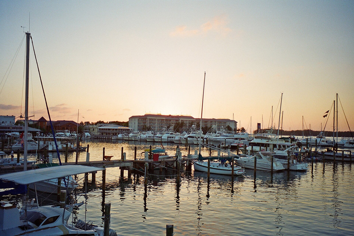 Moored sailboats and waterfront buildings at Key West Bight marina at sunset